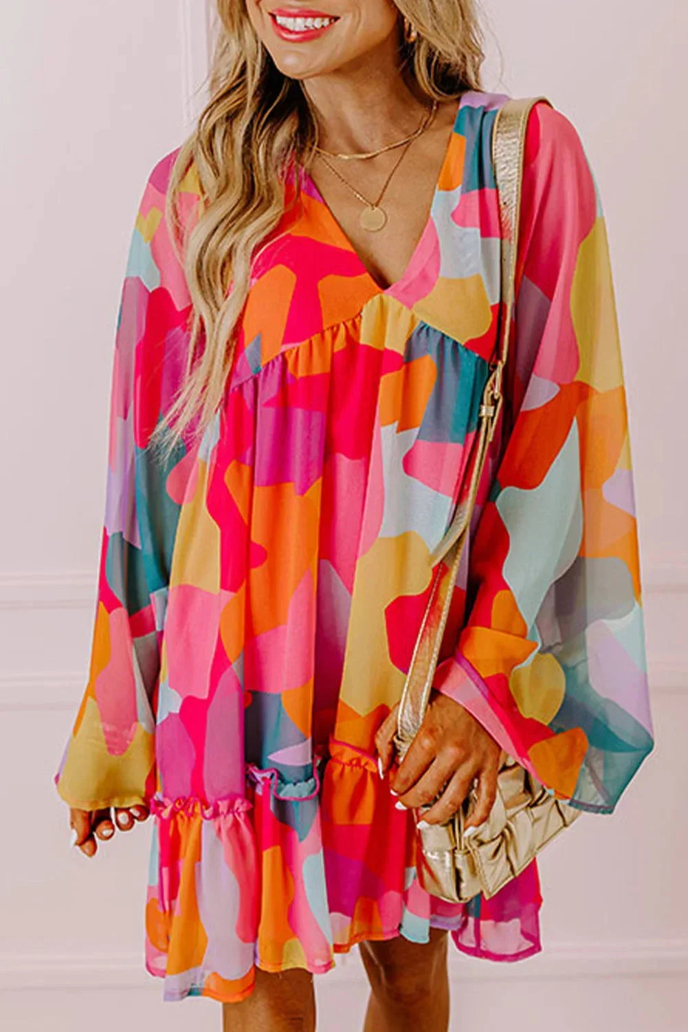 Robe courte colorée avec décolleté en V, manches longues, en coton léger, parfaite pour les journées d'été à la plage.