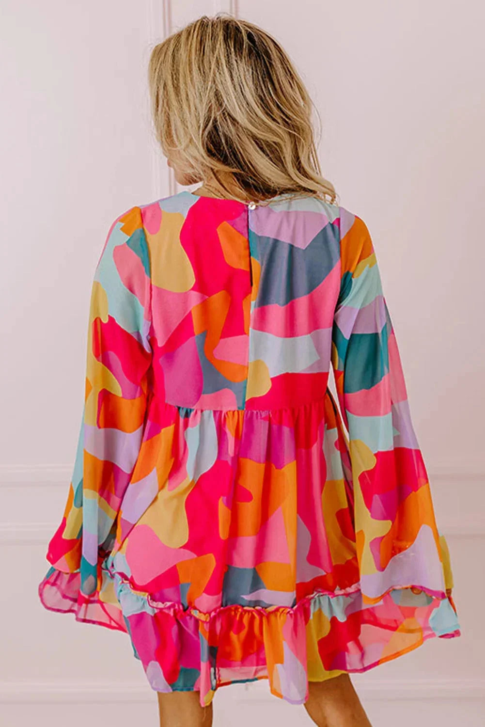 Robe courte colorée à imprimé floral, décolleté en V, manches longues, idéale pour des jours d'été à la plage.