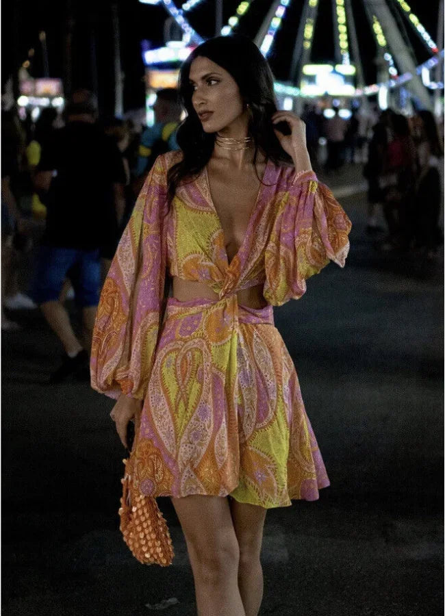 Robe courte col V à manches longues, imprimée rose et jaune, coupe portefeuille fluide, idéale pour l'été et la plage.