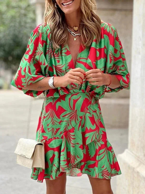 Robe courte rouge à imprimé tropical, en tissu léger avec manches évasées, idéale pour les journées d'été à la plage.