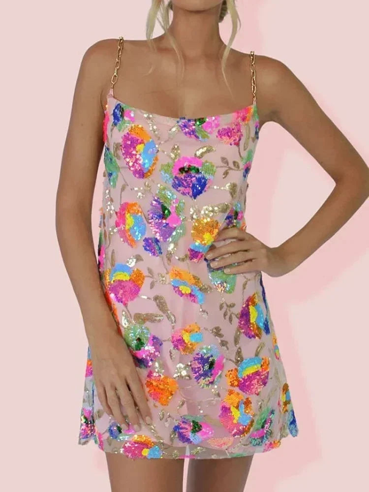 Robe courte à bretelles, tissu scintillant ajusté, imprimée de motifs vifs, idéale pour les soirées élégantes.