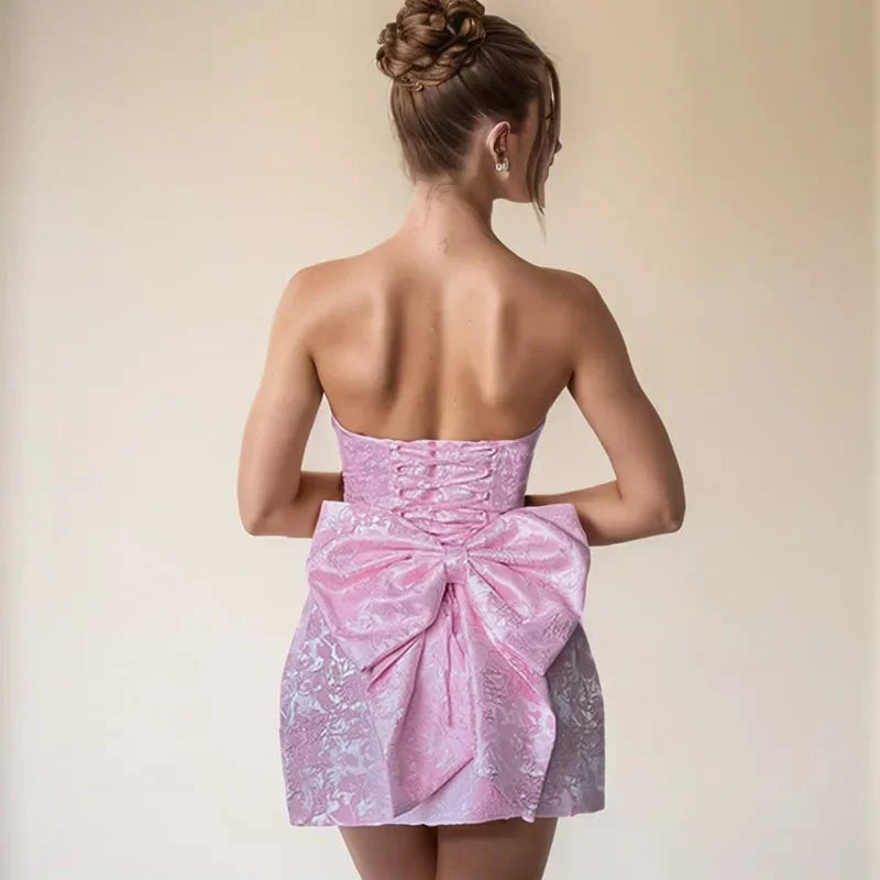 Robe courte jacquard dos nu, sans bretelles, avec un grand nœud à l'arrière et un motif texturé élégant.