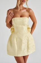 Robe courte en jacquard, dos nu, avec un grand nœud décoratif et sans bretelles, parfaite pour les occasions estivales.