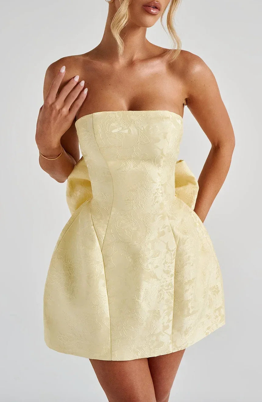 Robe courte en jacquard, dos nu, avec un grand nœud décoratif et sans bretelles, parfaite pour les occasions estivales.