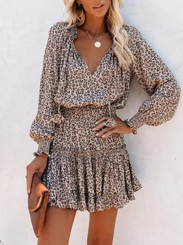 Robe courte léopard en tissu fluide, avec volants, col V et manches longues, idéale pour des soirées élégantes.