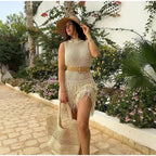 Robe courte sans manches en maille ivoire, ornée de franges, parfaite pour des journées d'été sur la plage.