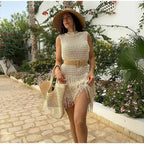 Robe courte sans manches en maille ivoire, décorée de franges, idéale pour un look décontracté à la plage en été.