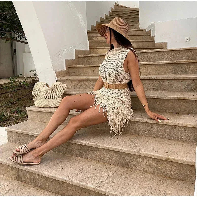Robe courte sans manches en maille ivoire, ornée de franges, idéale pour un look décontracté à la plage cet été.