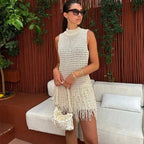 Robe courte sans manches ivoire en maille, ornée de franges, idéale pour un look décontracté à la plage en été.