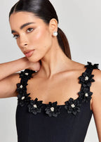 Robe courte noire sans manches, brodée de fleurs blanches, en tissu léger, idéale pour une soirée élégante.