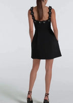 Robe courte noire en tissu léger, brodée de fleurs blanches, sans manches, idéale pour des soirées élégantes.