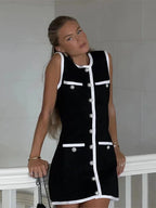 Robe courte noire sans manches avec détails en perles et bordure blanche, coupe ajustée idéale pour une soirée cocktail.