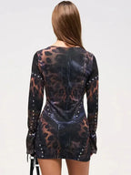 Robe courte noire en tissu fluide, imprimé abstrait, clous décoratifs, manches longues, idéale pour des soirées en club.