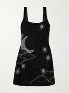 Robe courte noire en tissu pailleté, design fendu avec bretelles larges, idéale pour les soirées festives.