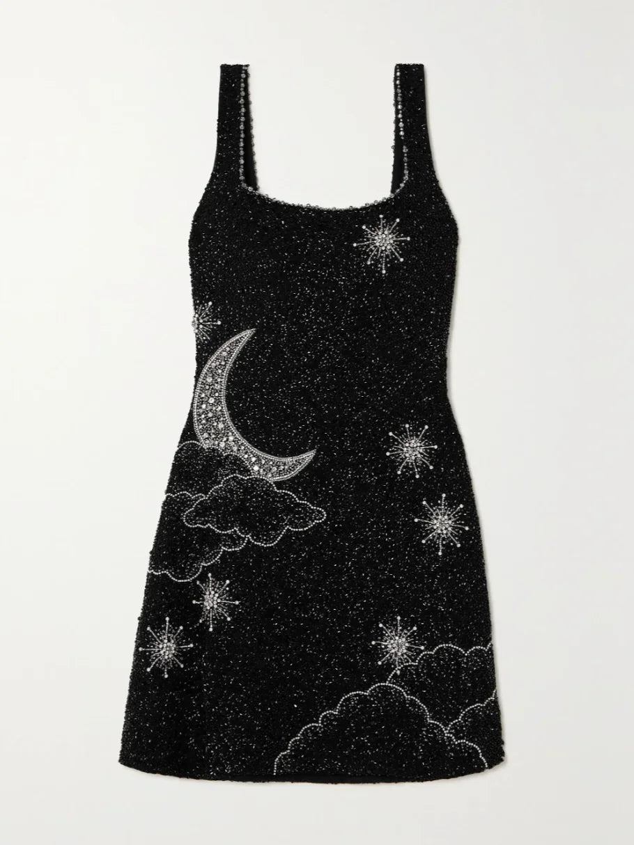 Robe courte noire en tissu pailleté, design fendu avec bretelles larges, idéale pour les soirées festives.