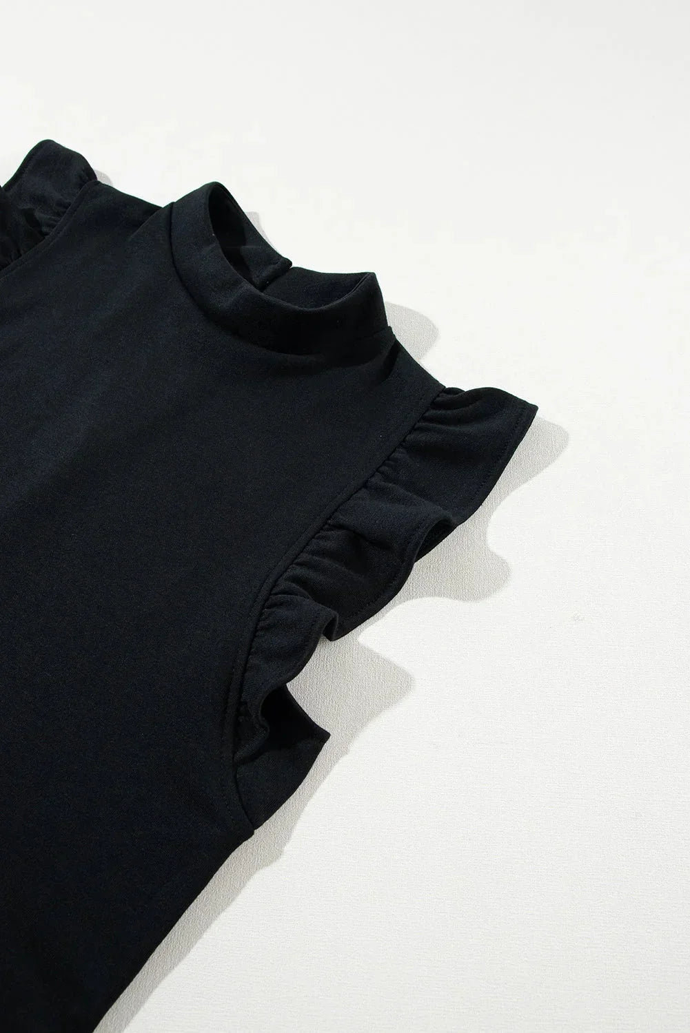 Robe courte noire à volants, manches courtes, coupe trapèze légère en tissu fluide, idéale pour les sorties en soirée.