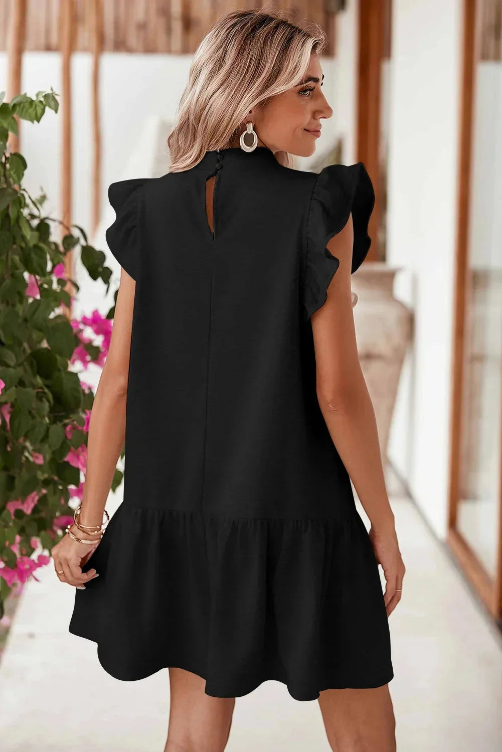 Robe courte noire à volants, manches courtes, en tissu léger, coupe trapèze pour un look décontracté et élégant en soirée.