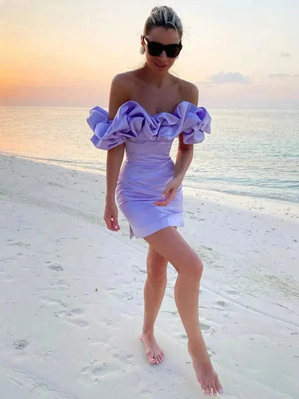 Robe courte off-shoulder en soie avec volants, disponible en plusieurs couleurs, coupe ajustée pour une silhouette féminine.