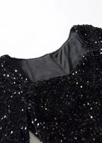 Robe courte noire à paillettes, manches longues, col en cœur, coupe ajustée, idéale pour les soirées festives.