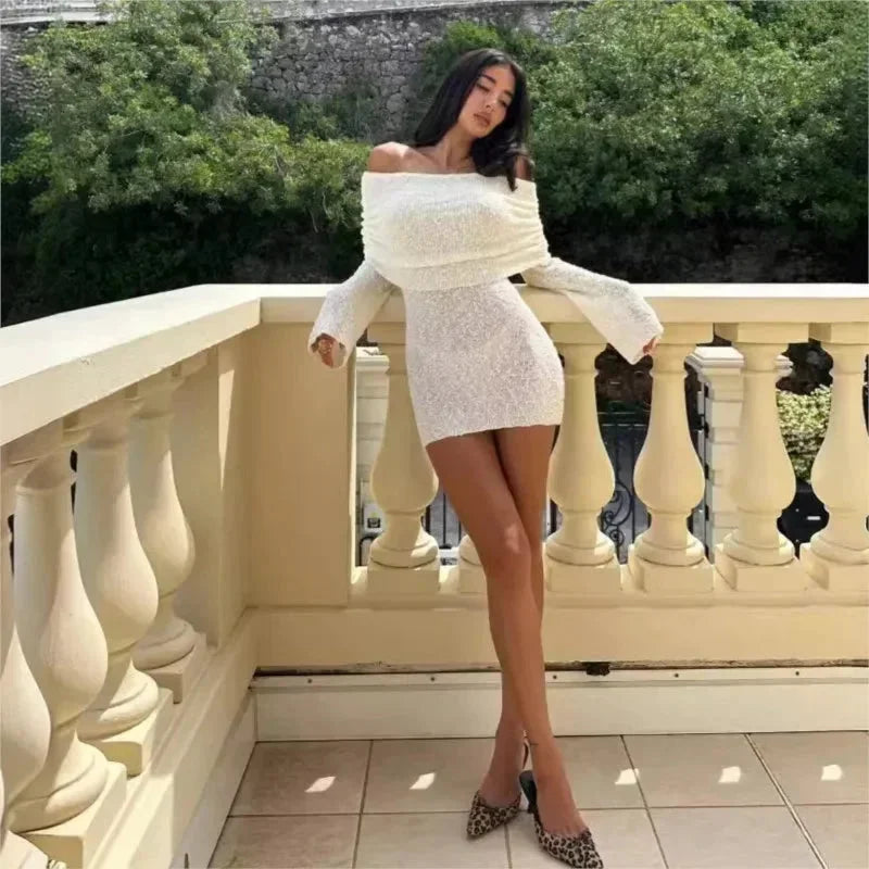 Robe courte pailletée, épaules dénudées, manches longues, tissu léger et brillant, idéale pour les événements ensoleillés.