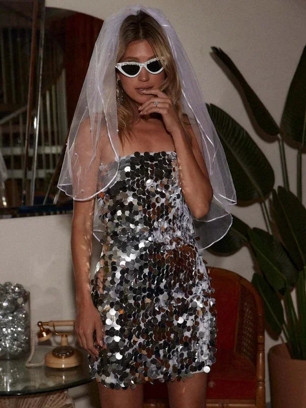 Robe courte pailletée sans bretelles, dos nu, en tissu scintillant multicolore, parfaite pour des soirées estivales.