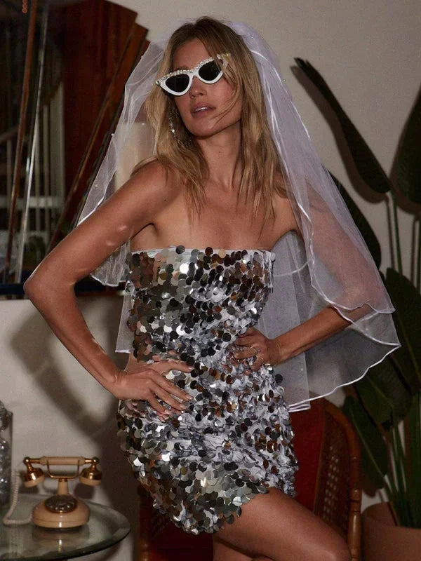 Robe courte pailletée sans bretelles, dos nu, en tissu scintillant aux multiples couleurs pour une soirée festive.