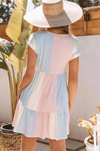 Robe courte pastel à volants, manches courtes, coupe évasée en tissu léger, idéale pour l'été à la plage.