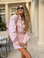 Robe courte rayée rose à manches longues, en coton léger, avec fente pour une journée de printemps.