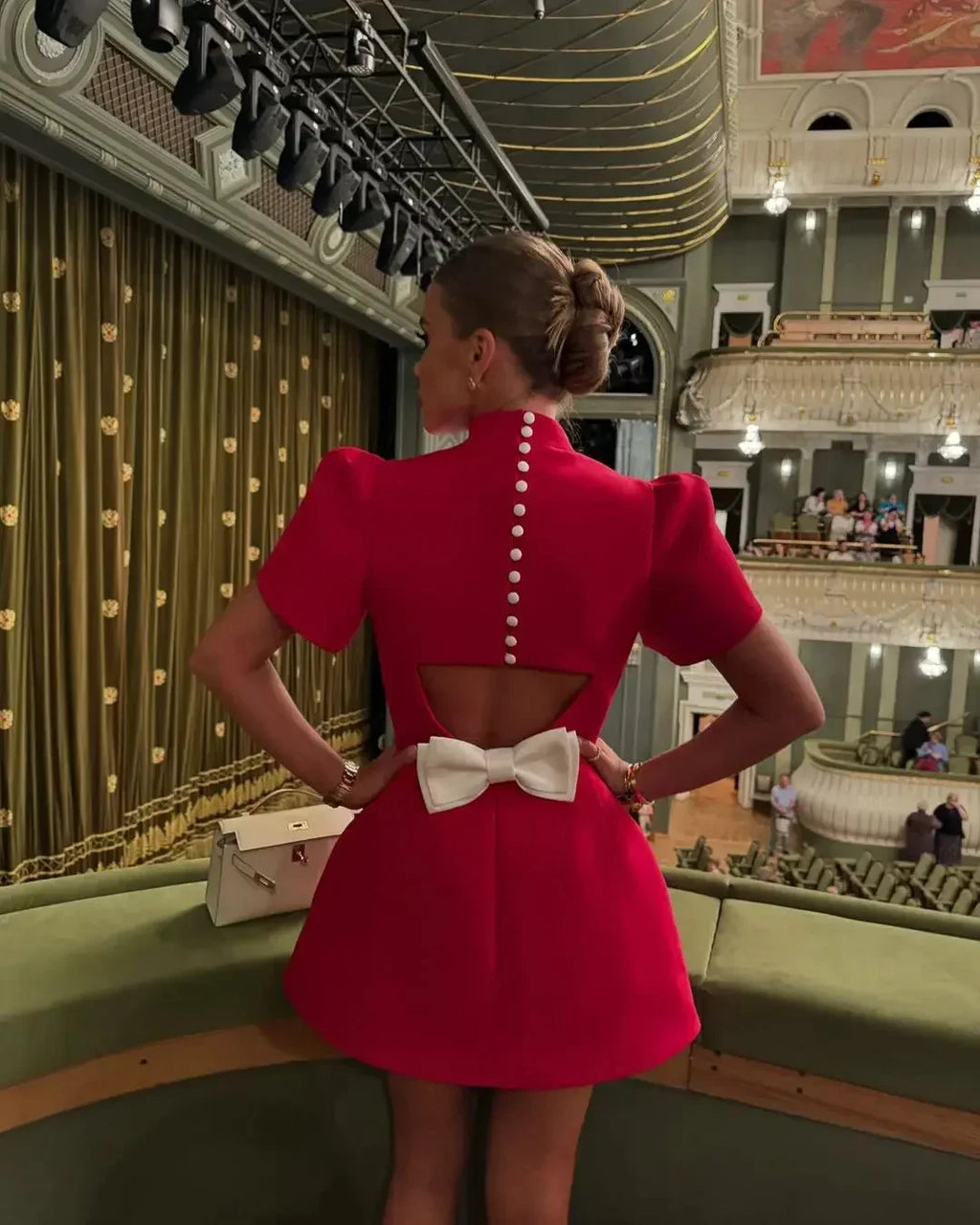 Robe courte rouge en tissu léger, avec boutons et dos ouvert orné d'un nœud, idéale pour les soirées.