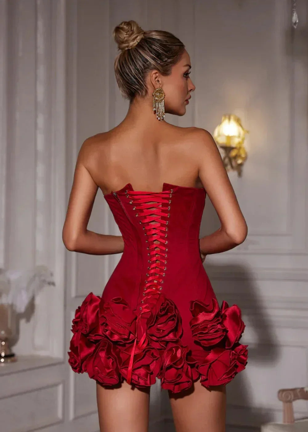 Robe courte rouge bustier avec une rosette en satin sur le décolleté, idéale pour des soirées élégantes.