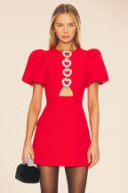 Robe courte rouge avec motif cœur en sequins, manches bouffantes, idéale pour une soirée festive.