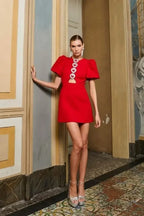 Robe courte rouge en tissu léger, ornée de cœurs en paillettes et manches bouffantes, idéale pour les soirées.