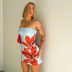 Robe courte sans bretelles fleurie en coton léger, bleu/rouge ou vert, idéale pour soirées d'été avec motifs floraux vibrants.