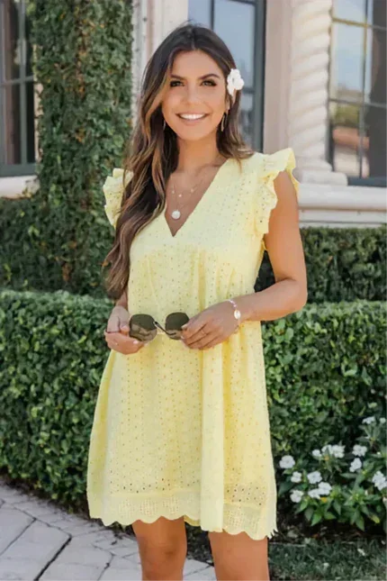 Robe courte sans manches en dentelle avec poches, parfaite pour les journées d'été à la plage ou en vacances.