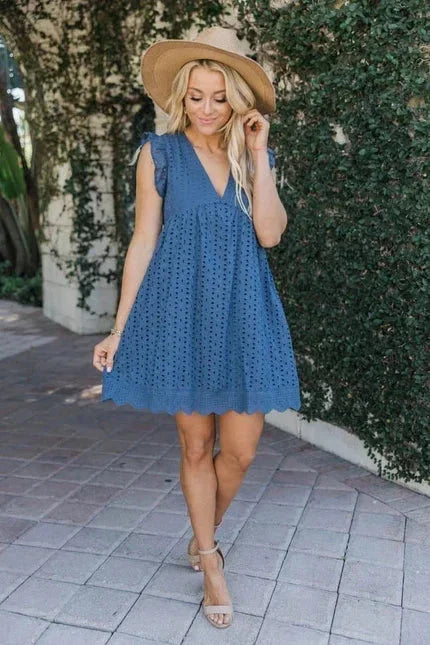 Robe courte sans manches en dentelle légère avec poches, idéale pour les journées d'été à la plage ou en vacances.