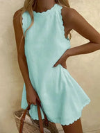 Robe courte sans manches en tissu léger, avec ourlet festonné, idéale pour l'été et les journées à la plage.