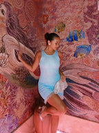 Robe courte sans manches en satin bleu, ornée de paillettes et de franges pour une allure festive et moderne.