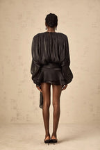 Robe courte satinée fluide avec nœuds aux manches longues, idéale pour une soirée, disponible en plusieurs couleurs.