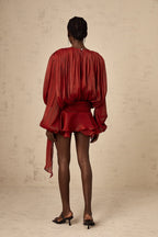 Robe courte en satin fluide avec nœuds aux manches longues, idéale pour soirées, disponible en plusieurs couleurs.