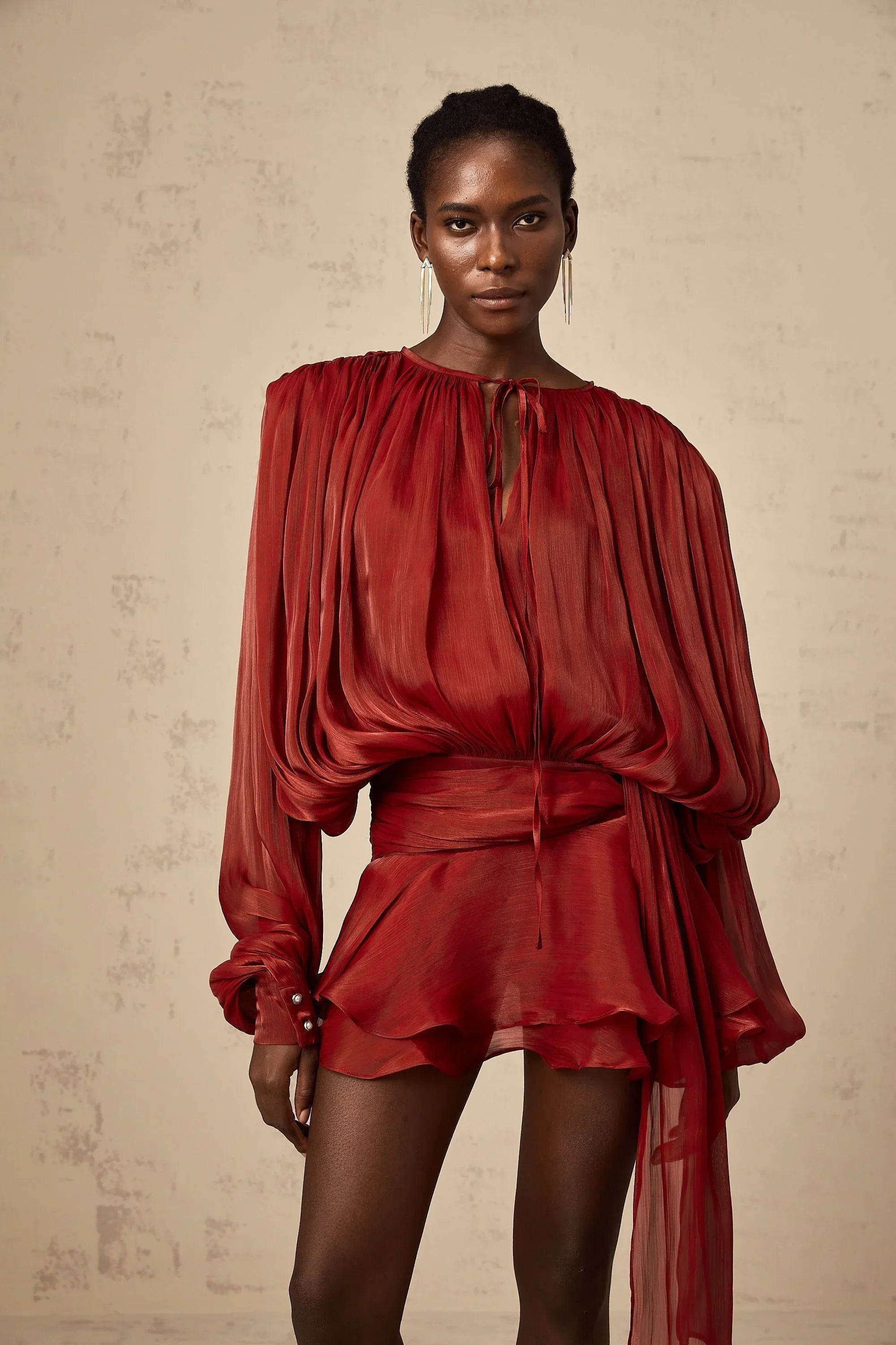 Robe courte satinée fluide avec nœuds aux manches longues, idéale pour soirées, en plusieurs coloris élégants.