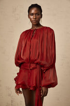 Robe fluide en satin avec nœuds aux manches longues, parfaite pour une soirée, disponible en plusieurs couleurs.