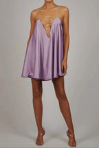 Robe courte satinée fluide avec chaînes décoratives, idéale pour une soirée chic, en tissu léger et coupe élégante.