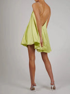 Robe courte en satin fluide avec chaînes décoratives, idéale pour une soirée élégante et confortable.