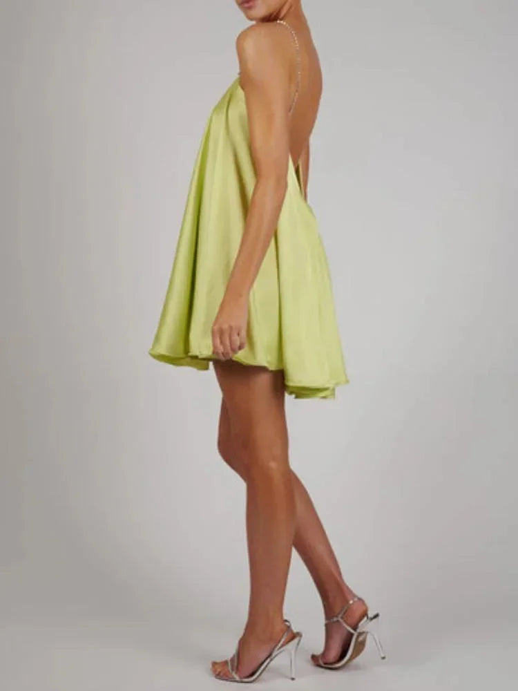 Robe courte en satin fluide avec chaînes décoratives, parfaite pour une soirée élégante. Détails raffinés et coupe moderne.