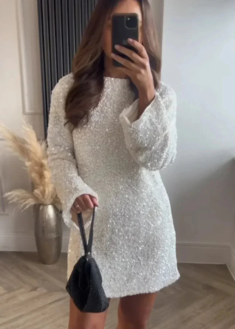 Robe courte blanche à manches longues avec tissu scintillant, col chic, idéale pour les soirées élégantes.