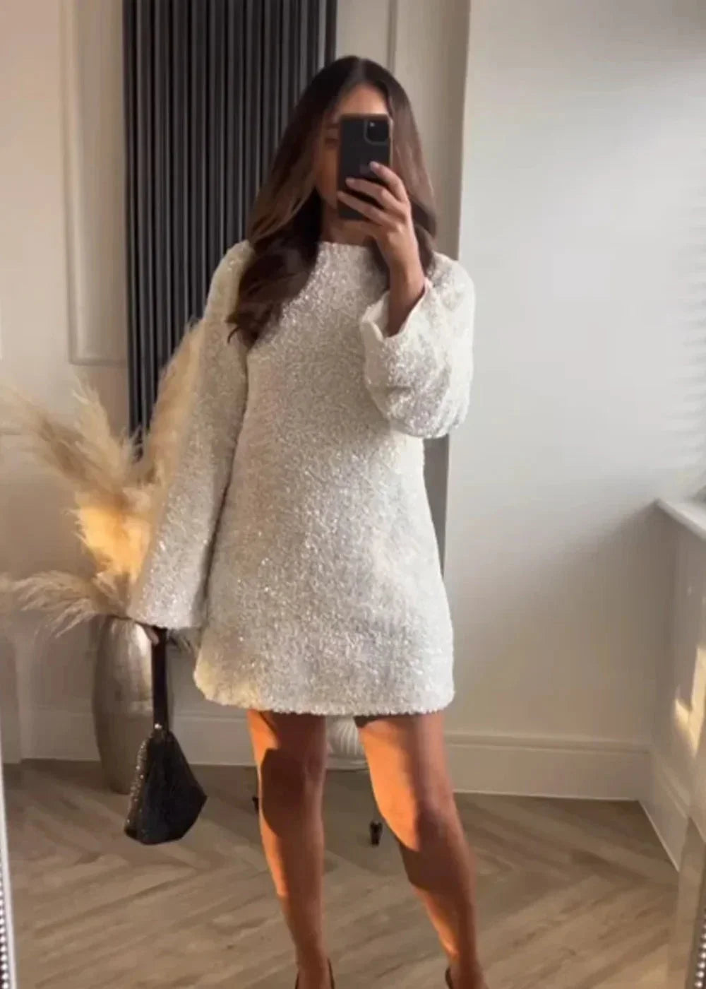 Robe courte blanche à manches longues, tissu brillant, col chic, idéale pour soirées élégantes et intemporelles.