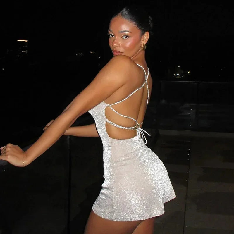 Robe courte en sequins, dos nu avec bretelles croisées, idéale pour soirées clubbing, tissu brillant et ajustement confortable.