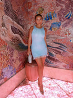 Robe courte à franges sans manches en tissu scintillant, idéale pour les soirées clubbing, avec une coupe audacieuse.