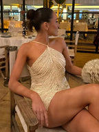 Robe courte asymétrique à sequins, col licou, en tissu scintillant, idéale pour des soirées cocktail.