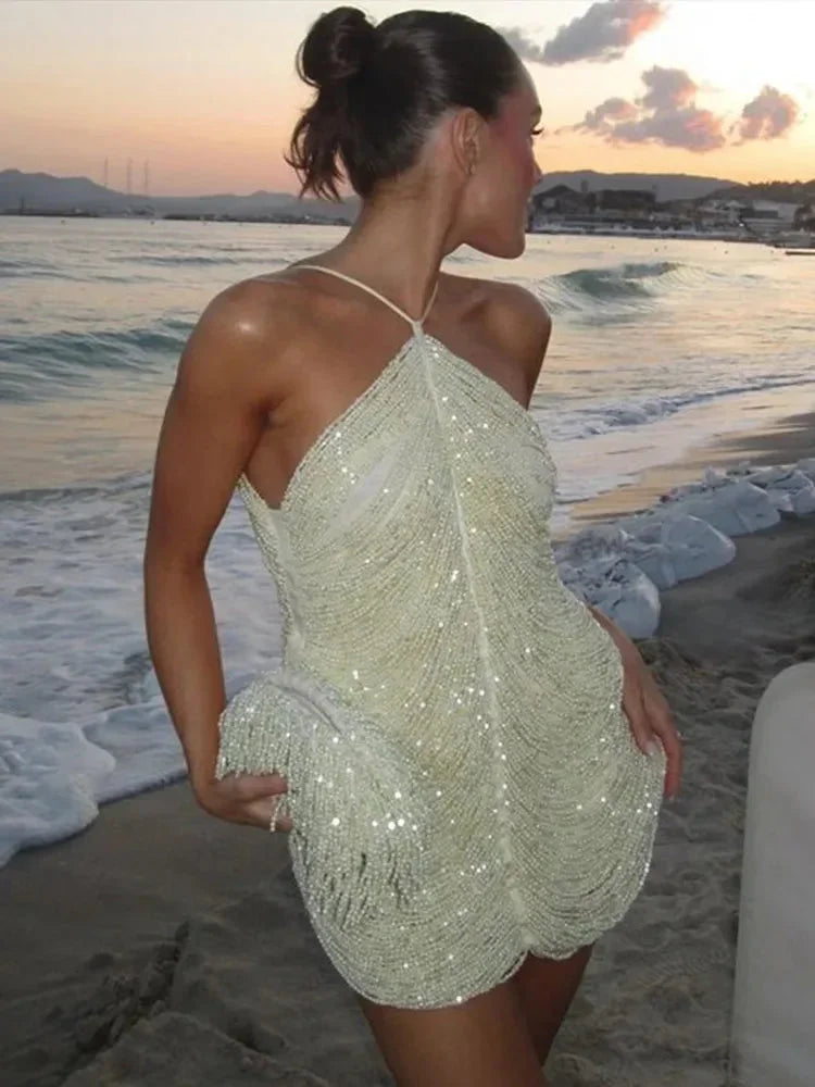 Robe courte asymétrique en tissu scintillant avec col licou, idéale pour les soirées cocktail et les occasions spéciales.